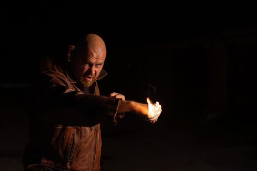 Bald Caucasian man beats with a burning fist