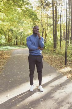 African american student walking in the park.