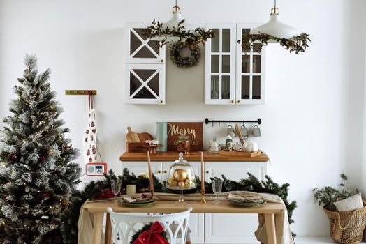 The interior of the modern kitchen is decorated for Christmas. Christmas tree in the kitchen