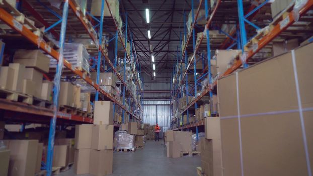 Worker in shipping warehouse using touch screen digital tablet entering data or barcode. Handsome professional men wearing white shirt and hard hat. Portrait busy male at work.