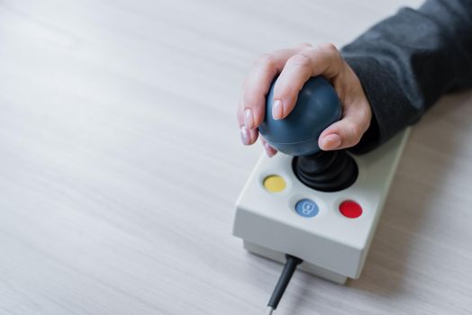 Woman with cerebral palsy works on a specialized computer mouse