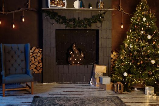Dark modern interior with Christmas tree and faux fireplace.