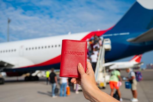 A woman gets on a plane and holds a passport.