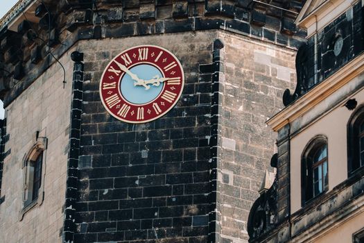 Dresden, the red great clock of the Dresden castle tower, the residence of the old kings in the city center, the Baroque Museum complex, illuminated by the sun.