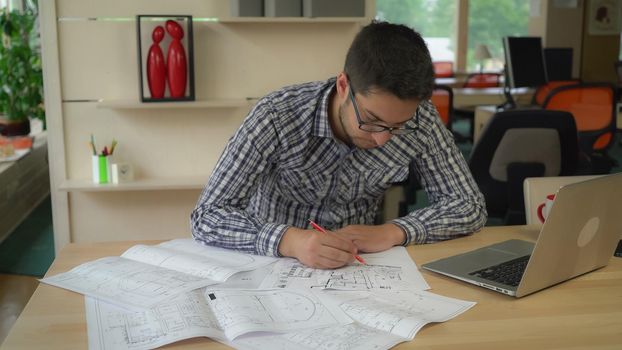 mixed race man holding pencil and line sitting at the working place drawing