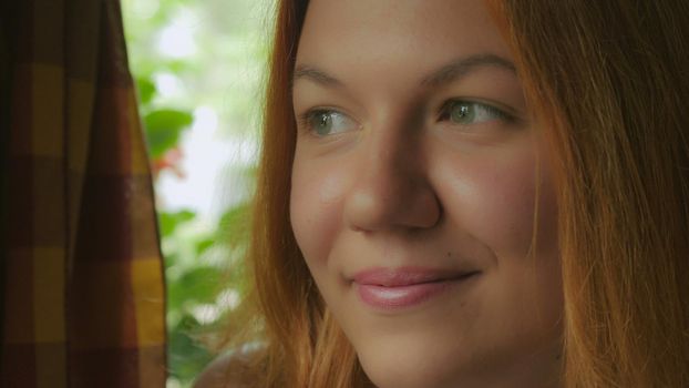 Portrait happy smiling young woman looking at the camera. Redhead girl with bright red long hair posing with cheerful smile. Attractive millennial women.