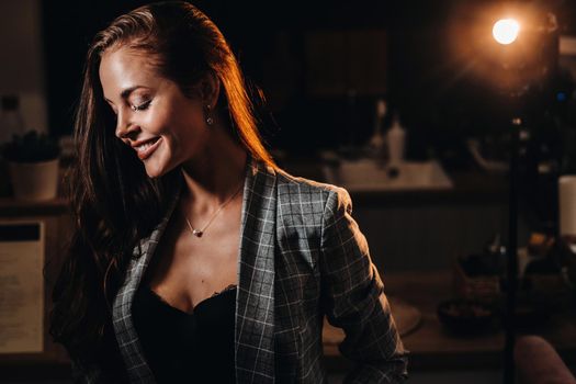 Portrait of a young European girl with long hair in a coffee shop in the evening light, a tall Girl in a jacket with long hair in a cafe.