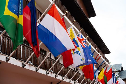 Many flags of different states fluttering on the facade of building, close up