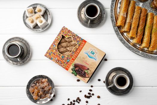 Top view of Turkish sweets and Turkish coffee on white wooden background, close up