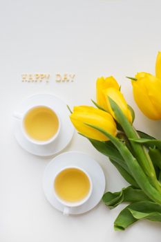 Beautiful yellow tulips on the table, the inscription happy day. valentine card