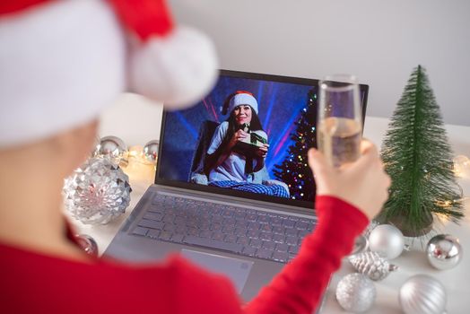 Caucasian woman calls family online on laptop and wishes a Merry Christmas. Remote meeting of the new year.