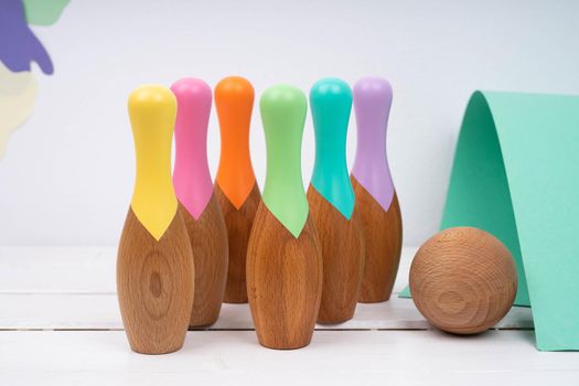 Skittles and a ball made of natural material. Bowling for children made of wood. Set for bowling. Children's wooden toys.