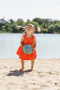 Cute little girl playing with ball on beach, kids summer sport outdoors.
