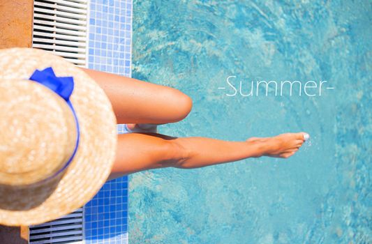 Beautiful girl in a hat near a blue pool - sun, summer, heat, summer inscription.