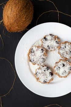 sweet coconut muffins on a white plate on a black board