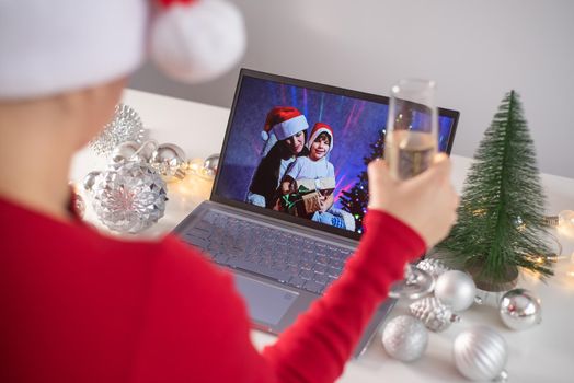 Caucasian woman calls family online on laptop and wishes a Merry Christmas. Remote meeting of the new year.