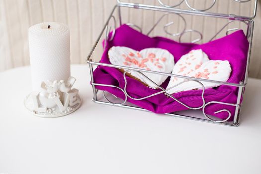 candle and biscuits in the form of heart on a pink napkin.