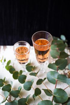 eucalyptus branches on an old table with a glass of rose wine