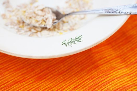 oatmeal in white bowl on orange napkin.