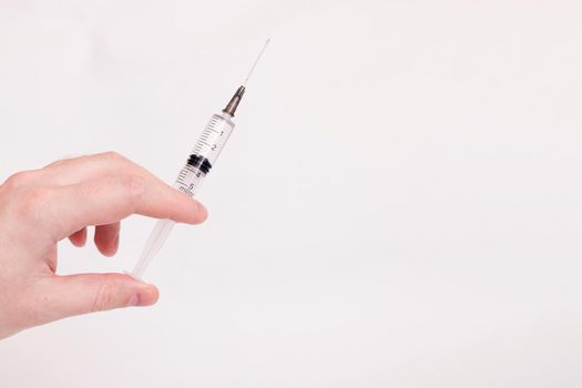 Syringe in hand on white background close up, copy space
