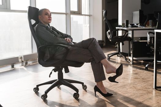 Young business woman bored sitting on a chair in the office
