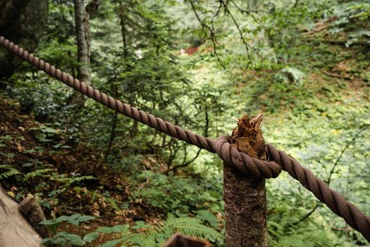 Dirty thick rope tied to a wooden fence, close up