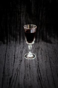 glass of red wine on a black velvet background, close-up.