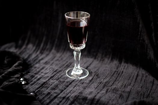 glass of red wine on a black velvet background, close-up.