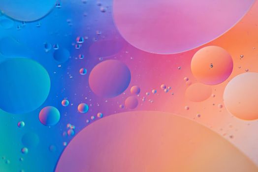 Colorful abstract background with oil drops on water. Blue orange color