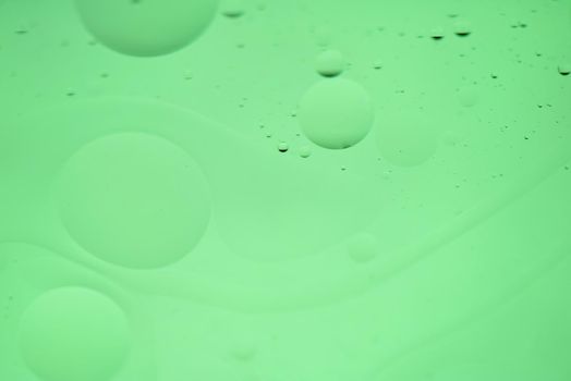 Oil drops in water. Defocused abstract psychedelic pattern image green mint colored. DOF.