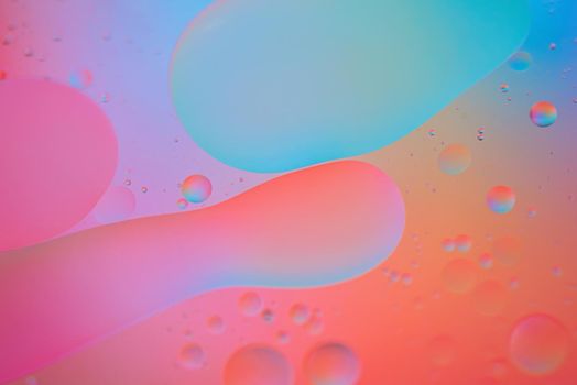 Oil drops in water. Defocused abstract psychedelic pattern image red, pink and blue colored. Abstract background with colorful gradient colors. DOF.