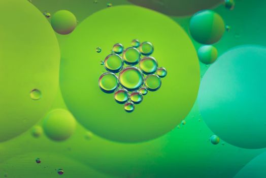 Oil drops in water. Abstract defocused psychedelic pattern image green colored. Abstract background with colorful gradient colors.