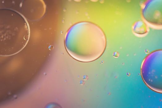 Oil drops in water. Abstract defocused psychedelic pattern image rainbow colored. Abstract background with colorful gradient colors. DOF.