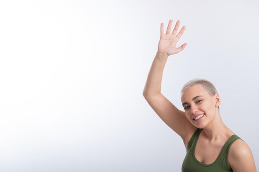 Young Caucasian Woman Holding Raised Hand White Background Smiling Girl Green Tshirt Short Blond Hair