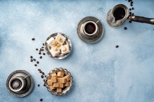Top view photo of Turkish delight and brown cubed sugar in oriental dishware on table