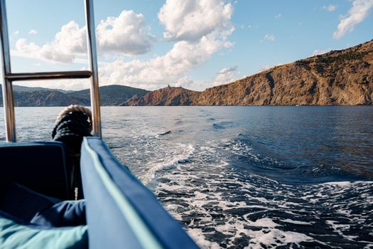 Motor yacht cruising in the open sea, view from the stern