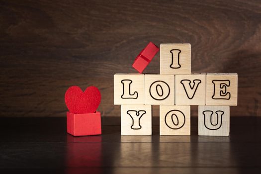 A declaration of love. Valentine's Day background. I love you. Wooden cubes. A box with a heart. Copy space.