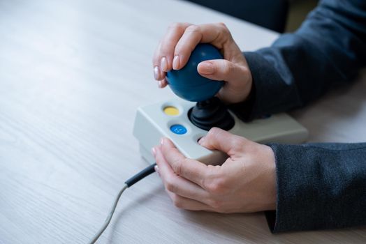 Woman with cerebral palsy works on a specialized computer mouse