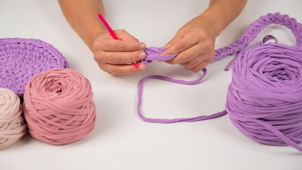Close-up of a woman crocheting a basket of cotton yarn