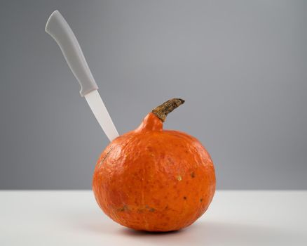 Knife in a pumpkin on a white background. Halloween symbol