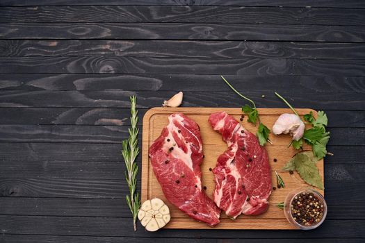 meat steak wooden board and spices ingredients top view. High quality photo