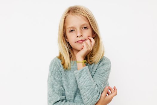 Beautiful little girl with blond hair on a light background. High quality photo