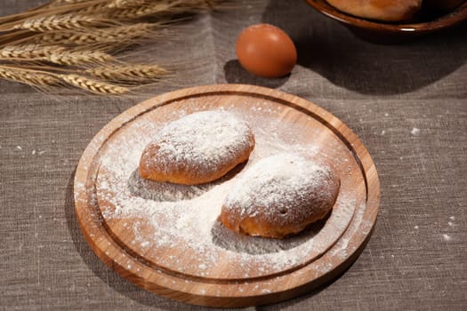 round cutting board in flour with two pies on a burlap