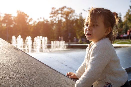 adorable toddler girl plays on a sunny fine day in the park. close up