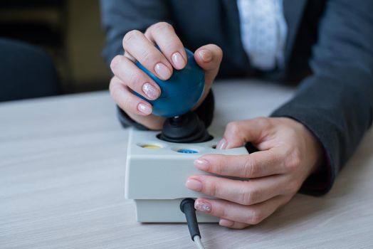 Woman with cerebral palsy works on a specialized computer mouse