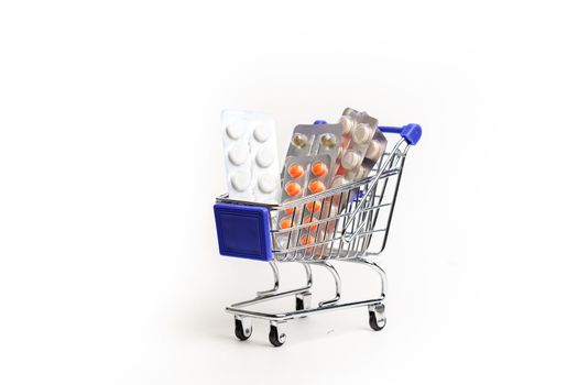 Shopping cart with pills on a white background . Medicines. Medicine. Purchase of medicines. The rise in price of medicines. Copy Space