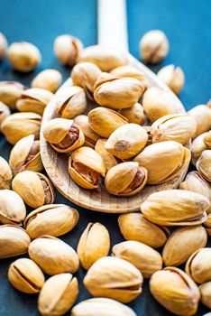 salt pistachios in a wooden spoon