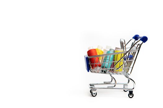 Trolley with thread on a white background . Thread selection. Shopping for needlework. White background. Copy space