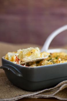 baked cauliflower with chicken fillet and vegetables topped with cheese in a ceramic mold