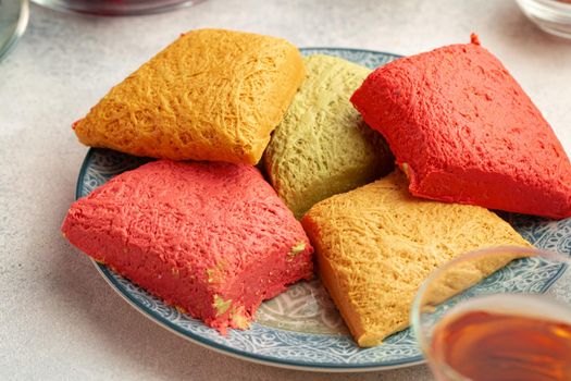 Assortment of colorful Turkish halva cakes on plate, close up